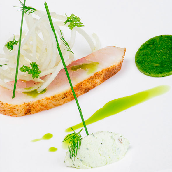 Exquisite plating: a slice of smoked or crusted fish (trout, salmon) with thin fennel rings, green herb oil/sauce, a dollop of ricotta or mascarpone cream with dill, and grass-like chive decorations.