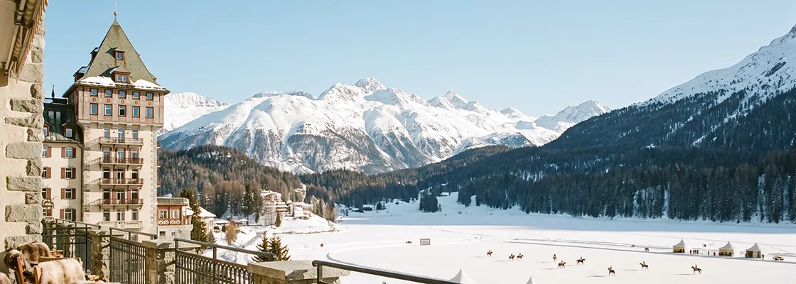 St. Moritz hotel by a frozen lake with horses