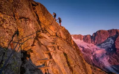 People passing a high altitude rope course on a rock in Val Thorens.
