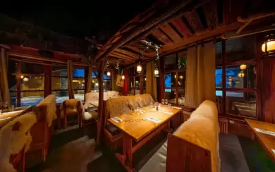 Cosy wooden interior of La Cabane restaurant with fur covers on chairs