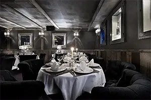 Elegant dark interior of La Mangeoire restaurant with set tables