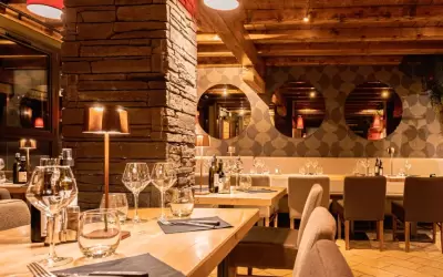 Cosy interior of Le Rendez-vous restaurant with a stone column and round mirrors
