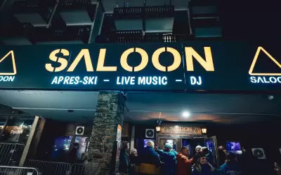 Glowing sign and entrance to Saloon apres-ski bar in Val Thorens