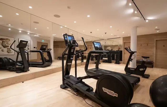 Fitness room with cardio machines and mirrored walls at Lys Martagon, Courchevel 1850