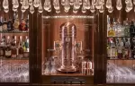 Back bar with spirits, glassware and a copper centrepiece under hanging crystals, Lys Martagon