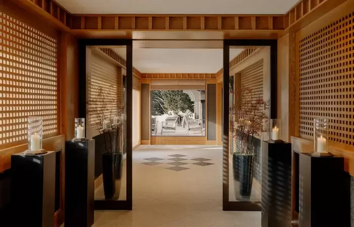 Lattice-panelled corridor leading in from the entrance at Aman Le Melezin