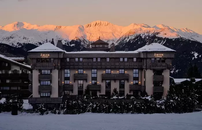 Aman Le Melezin at dusk below alpenglow on the peaks above Courchevel 1850