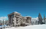 The hotel against a clear blue sky, snow to the foot of the facade