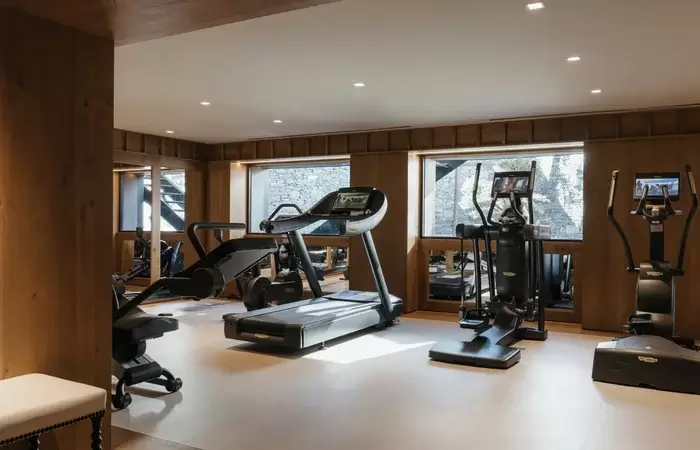 Fitness studio with cardio equipment and mountain windows