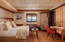 Superior room at Fouquets Courchevel with a bed and winter forest view.