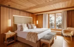 Elegant Deluxe Suite bedroom with access to a snowy terrac