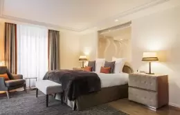 Junior Suite Mont-Blanc bedroom with orange cushions and bedside lamps, Hotel Mont-Blanc Chamonix