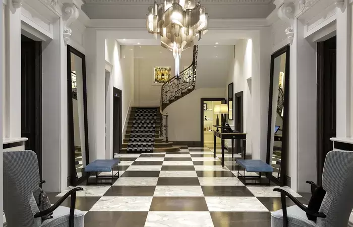 Entrance hall with chequered marble floor and spiral staircase, Hotel Mont-Blanc Chamonix