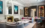 Lounge with marble fireplace, grey sofas and bookshelves at Hotel Mont-Blanc Chamonix