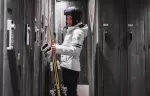 Woman with skis at a private wooden locker in the ski room, Hotel Mont-Blanc Chamonix