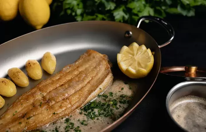 Fish with new potatoes served in a copper pan at L&rsquo;Altitude, Le K2 Altitude