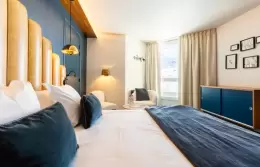 Desk area and double bed in a Double Room with slopes view, Fahrenheit Seven Val Thorens