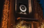Illuminated entrance of Fahrenheit Seven Val Thorens hotel with the F7 logo at night