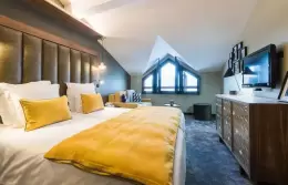 Bedroom with double bed and dormer window in the Duplex Top Floor Suite, Fahrenheit Seven Courchevel