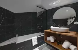 Black marble bathroom with bathtub and walk-in shower, Family Duplex Suite, Fahrenheit Seven Courchevel