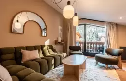 Living room with modular sofa and balcony in the Fahrenheit Seven Suite, Courchevel