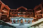 Illuminated facade of Fahrenheit Seven Courchevel hotel on a winter night