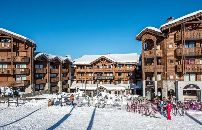 Skiers outside the snow front terrace of Fahrenheit Seven Courchevel on a sunny day