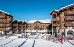 Skiers outside the snow front terrace of Fahrenheit Seven Courchevel on a sunny day