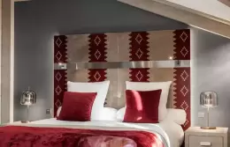 The red headboard and bed in a Premium Room at Le K2 Djola, Courchevel 1850