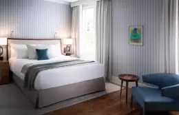 A Nest Room with a queen-size bed and a blue armchair at Chenot Palace Weggis