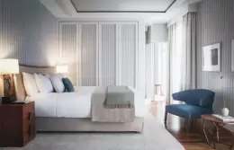 A Superior Room with a double bed and a blue armchair at Chenot Palace Weggis