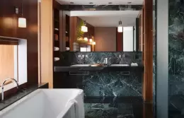 A Suite bathroom with a bathtub and dark green marble at Chenot Palace Weggis