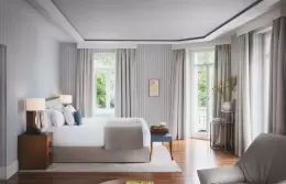 A Suite bedroom with a super king-size bed and balcony doors at Chenot Palace Weggis