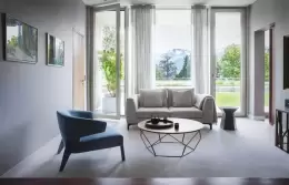 The separate living room of a Suite with a sofa and garden view, Chenot Palace Weggis
