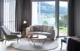 A sofa and open doors to the lake, Panorama Lake View Deluxe, Chenot Palace Weggis
