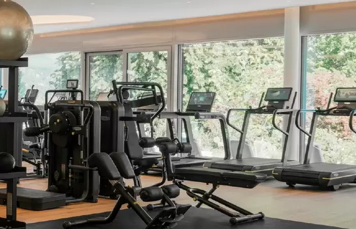 The fitness room with machines facing the garden windows, Chenot Palace Weggis
