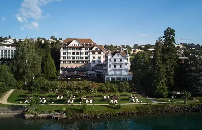 The hotel buildings and lakeside lawn seen from the water, Chenot Palace Weggis, Lake Lucerne