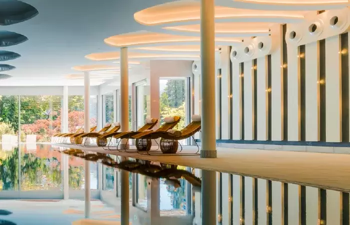 The indoor pool with wooden loungers and a sculpted ceiling, Chenot Palace Weggis