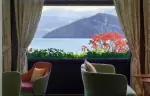 Armchairs at a window framing the lake and mountains, Chenot Palace Weggis, Weggis
