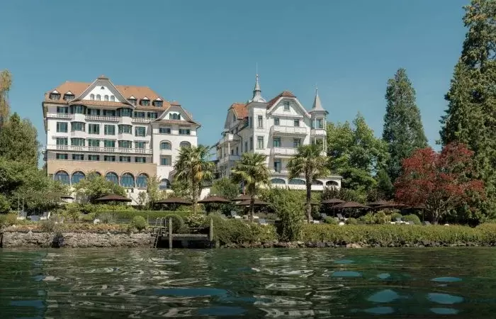 Historic facades and palm trees on the lake shore at Chenot Palace Weggis, Lake Lucerne