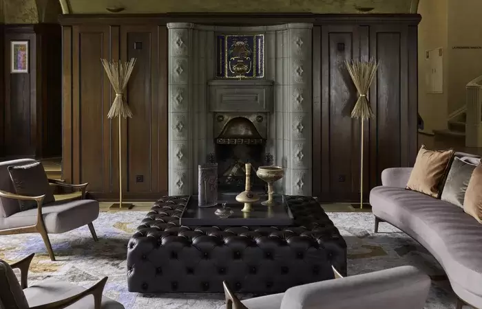 A lounge with a tiled stove and wood panelling at Chenot Palace Weggis, Lake Lucerne