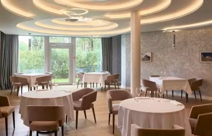 Laid tables in the restaurant with garden doors at Chenot Palace Weggis, Lake Lucerne