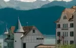 A turreted villa above the lake with mountains behind, Chenot Palace Weggis, Weggis