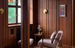A wood-panelled corner with an armchair and stained glass, Chenot Palace Weggis