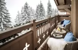 Prestige Suite bedroom with a corner fireplace under a wooden ceiling, Lys Martagon, Courchevel 1850