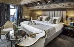 Deluxe Room 3 bedroom with a fireplace set below the television, Lys Martagon, Courchevel 1850