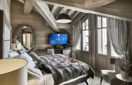 Deluxe Room 2 bed with a padded headboard and a grey throw, Lys Martagon, Courchevel 1850