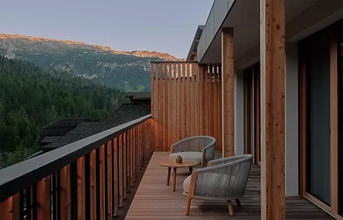 Room balcony with chairs and mountain views.