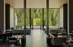 Spacious hotel lounge with panoramic forest views.