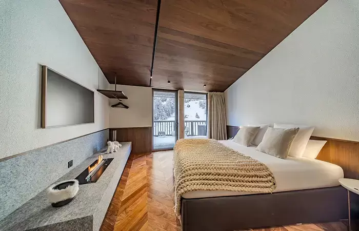 Bedroom with a fireplace in chalet Cristal in Val d-Isere.
